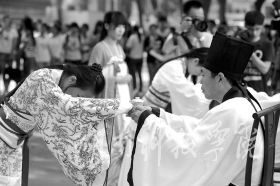 为纪念孔子诞辰2565周年，9月27日，德信网_德信(中国)学子身着华丽汉服在孔子雕像前隆重行拜师礼，现场展示汉礼、秀书法和茶艺，弘扬传统文化。
